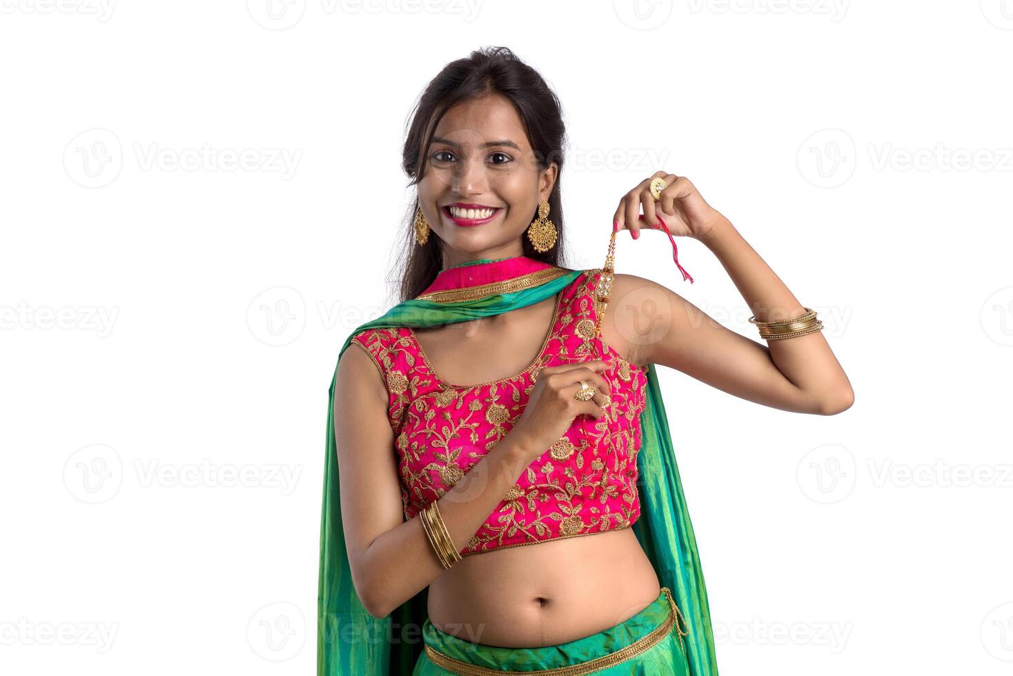 Beautiful girl showing Rakhi on occasion of Raksha bandhan on a white background. Sister tie Rakhi as symbol of intense love for her brother. photo