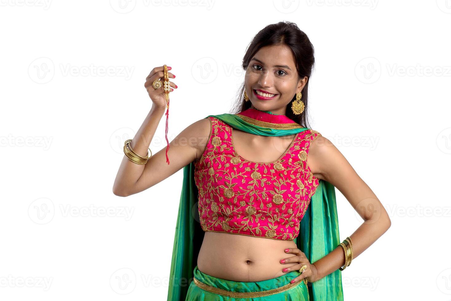 Beautiful girl showing Rakhi on occasion of Raksha bandhan on a white background. Sister tie Rakhi as symbol of intense love for her brother. photo