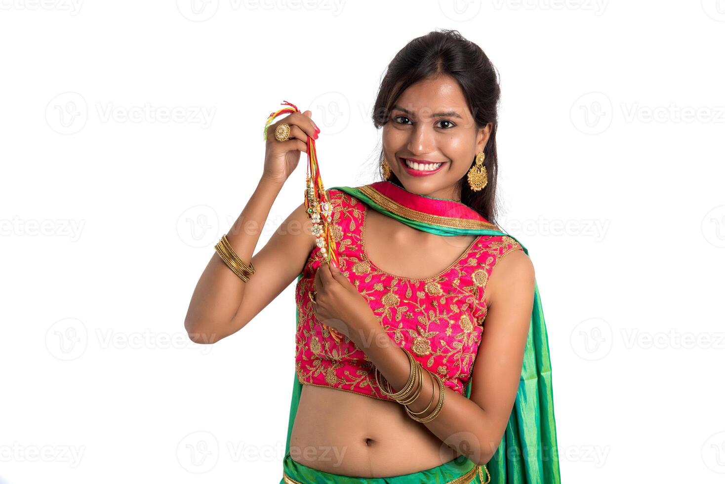 Beautiful girl showing Rakhi on occasion of Raksha bandhan on a white background. Sister tie Rakhi as symbol of intense love for her brother. photo