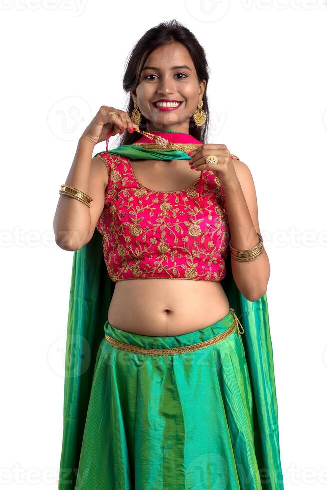 Beautiful girl showing Rakhi on occasion of Raksha bandhan on a white background. Sister tie Rakhi as symbol of intense love for her brother. photo