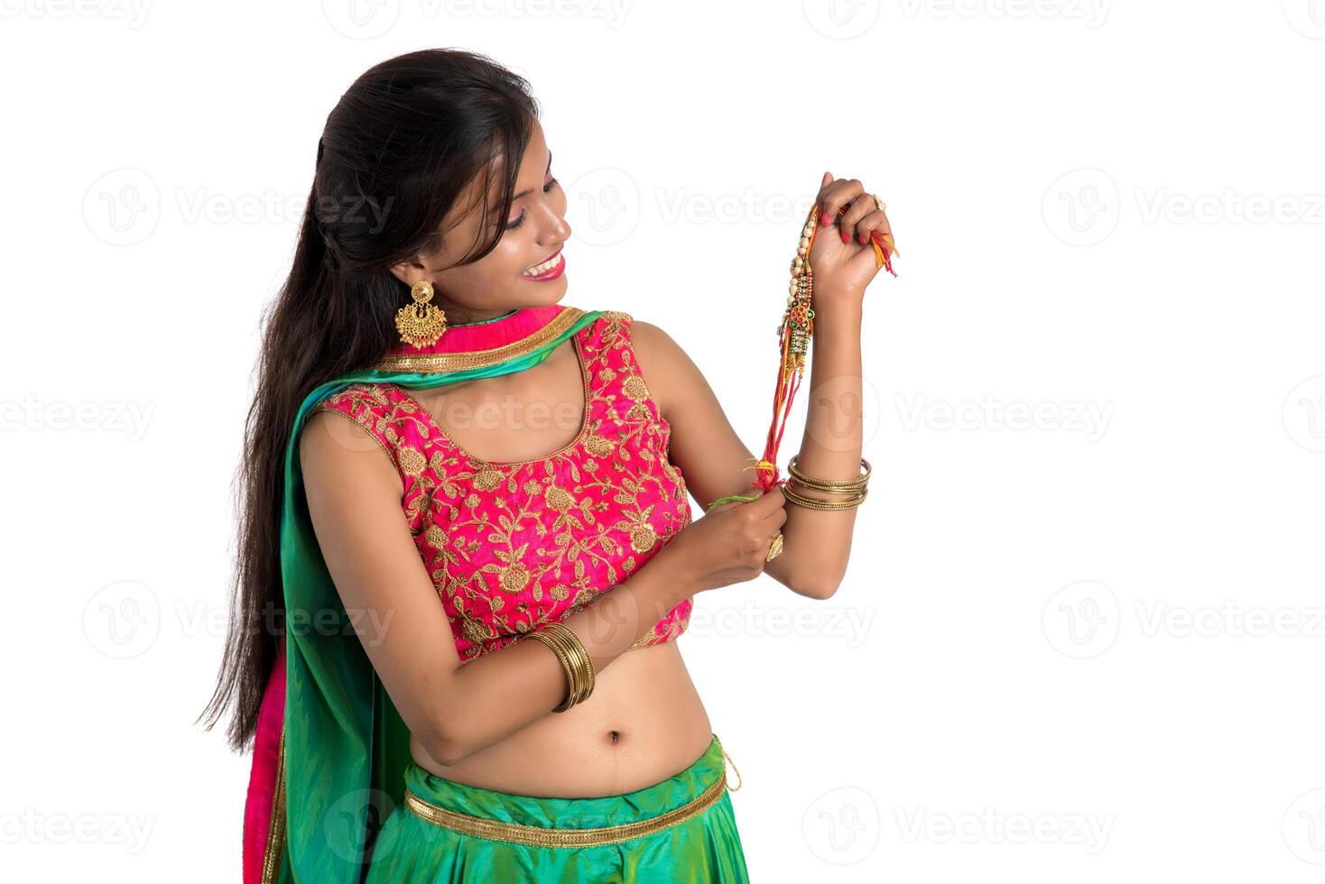 Beautiful girl showing Rakhi on occasion of Raksha bandhan on a white background. Sister tie Rakhi as symbol of intense love for her brother. photo