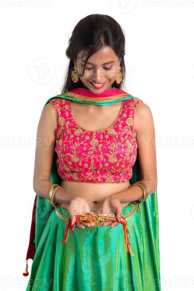 Beautiful girl showing Rakhi on occasion of Raksha bandhan on a white background. Sister tie Rakhi as symbol of intense love for her brother. photo
