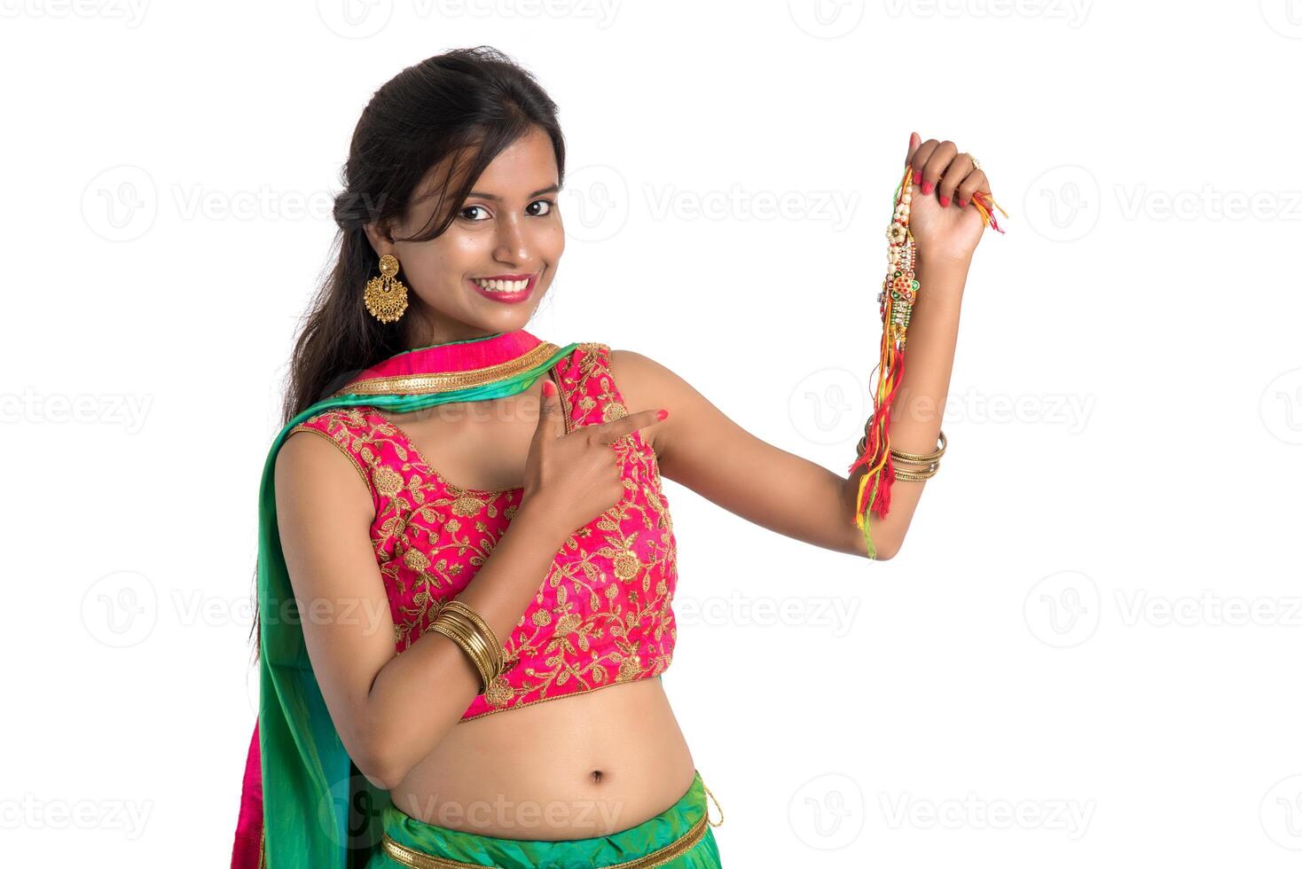 Beautiful girl showing Rakhi on occasion of Raksha bandhan on a white background. Sister tie Rakhi as symbol of intense love for her brother. photo