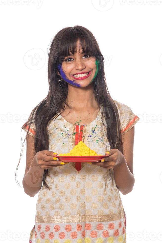 Beautiful young girl holding powdered color in plate on the occasion of Holi festival. photo