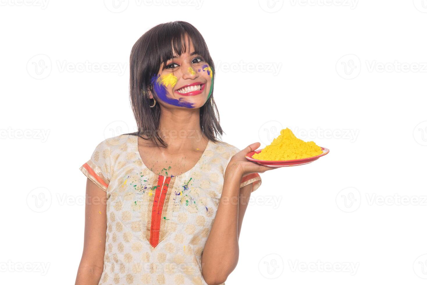 Beautiful young girl holding powdered color in plate on the occasion of Holi festival. photo