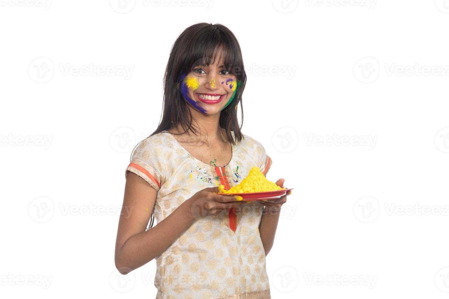 Beautiful young girl holding powdered color in plate on the occasion of Holi festival. photo