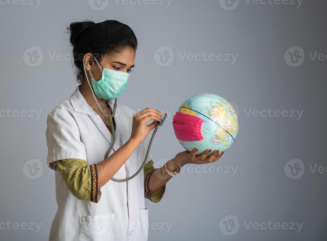 Female doctor listening to the Earth globe with stethoscope photo