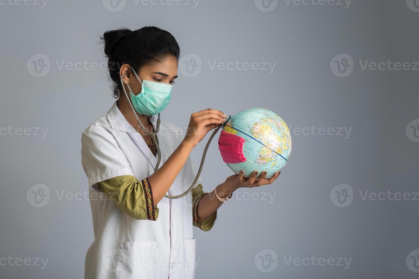 Female doctor listening to the Earth globe with stethoscope photo