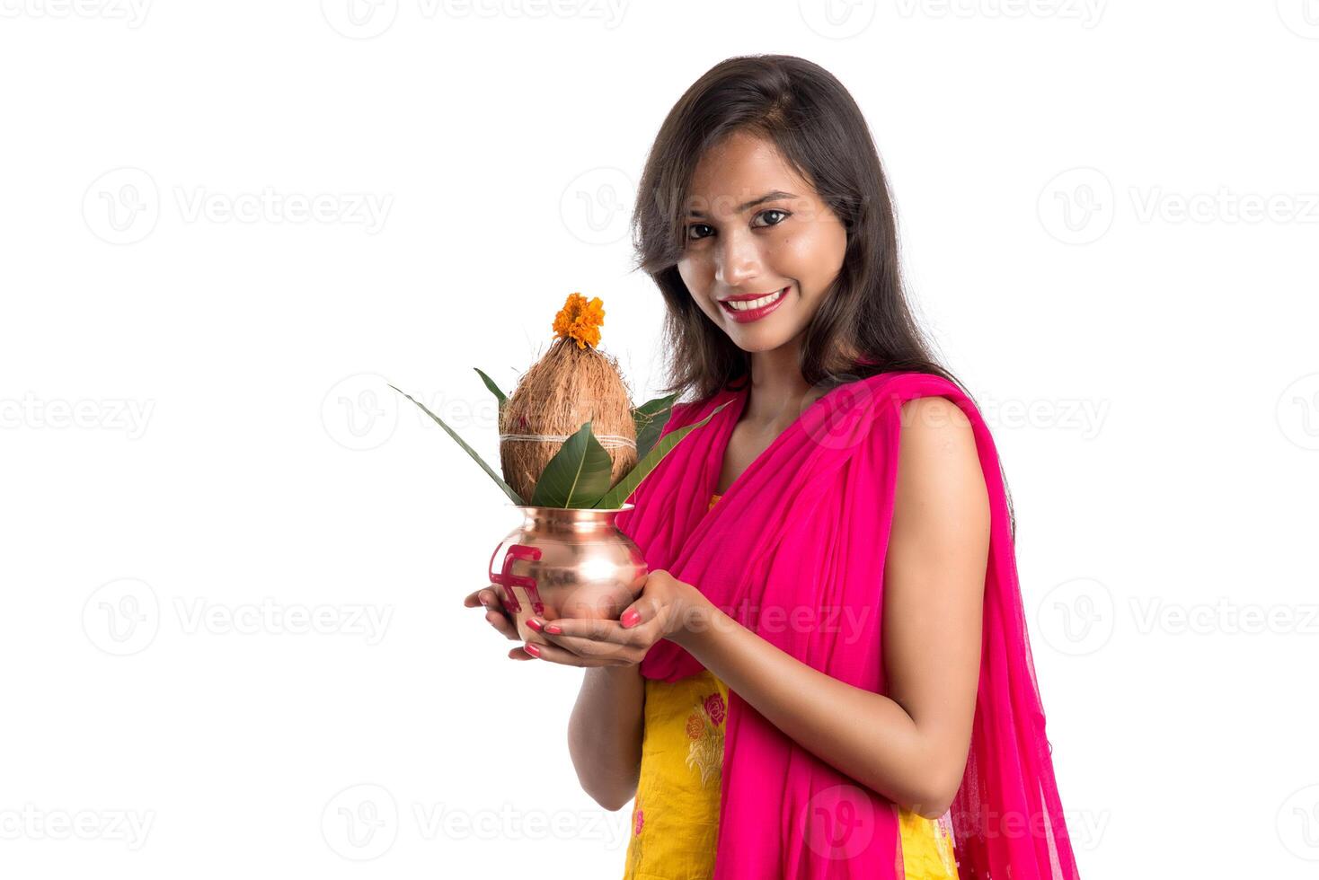 Indian girl holding a traditional copper Kalash, Indian Festival, copper Kalash with coconut and mango leaf with floral decoration, essential in Hindu Pooja. photo