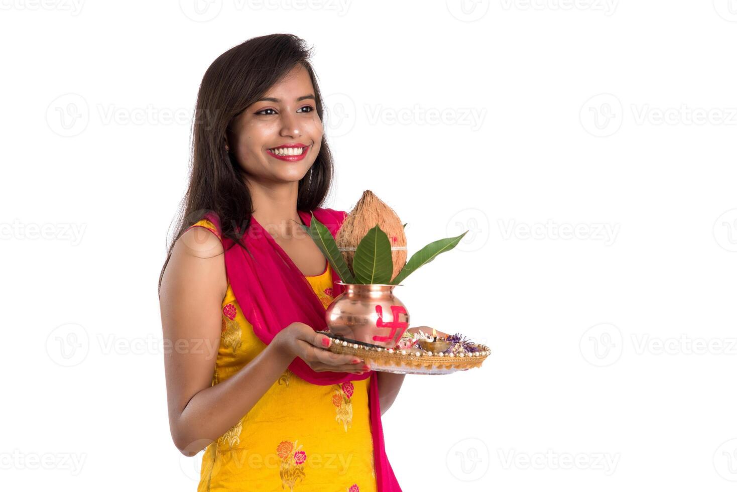 Indian girl holding a traditional copper Kalash with Pooja Thali, Indian Festival, copper Kalash with coconut and mango leaf with floral decoration, essential in Hindu Pooja. photo