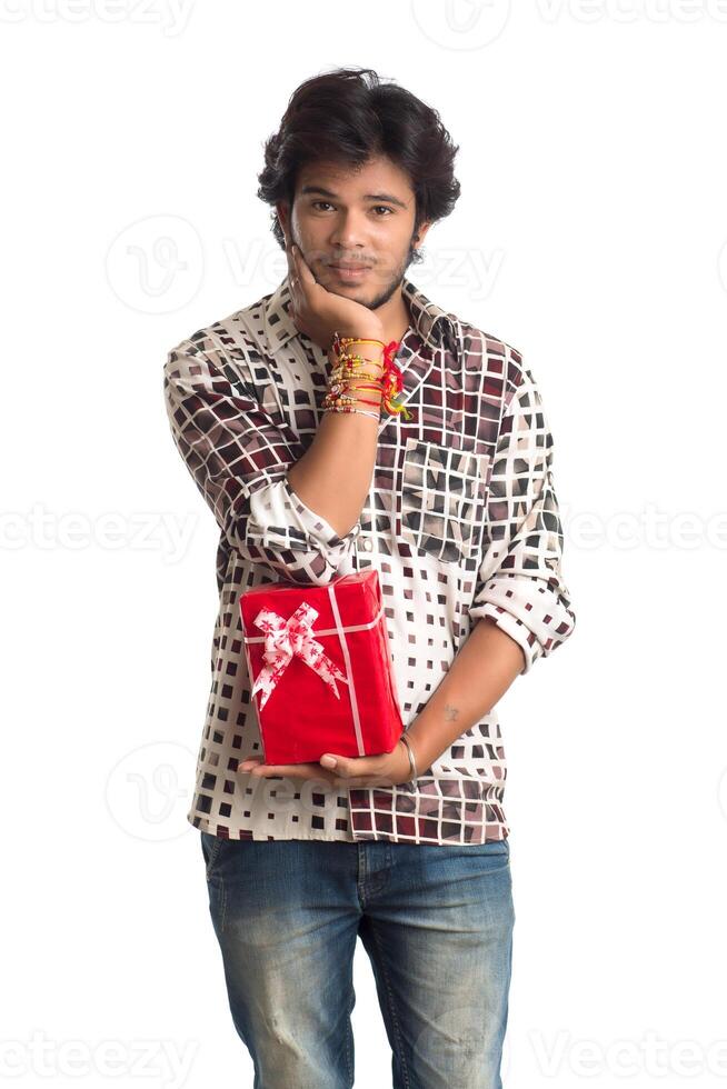 Man or Brother showing rakhi on his hand with shopping bags and gift box on the occasion of Raksha Bandhan festival. photo