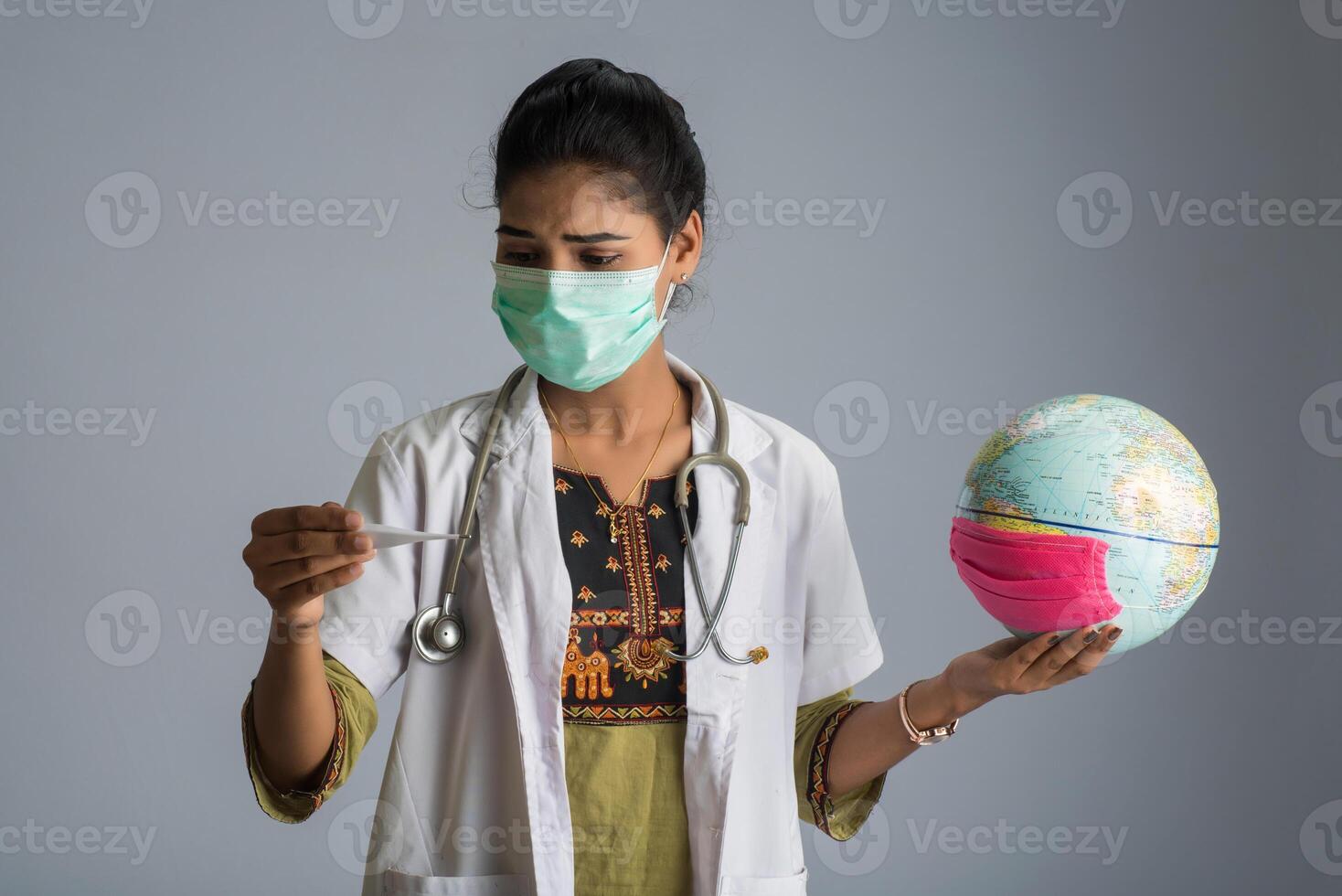 woman doctor holding Earth globe for presenting virus pandemic outbreak on the whole planet. Global warming and temperature rising presentation. photo