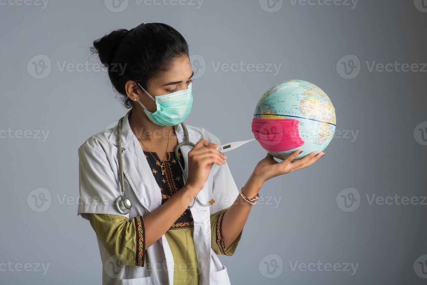 woman doctor holding Earth globe for presenting virus pandemic outbreak on the whole planet. Global warming and temperature rising presentation. photo