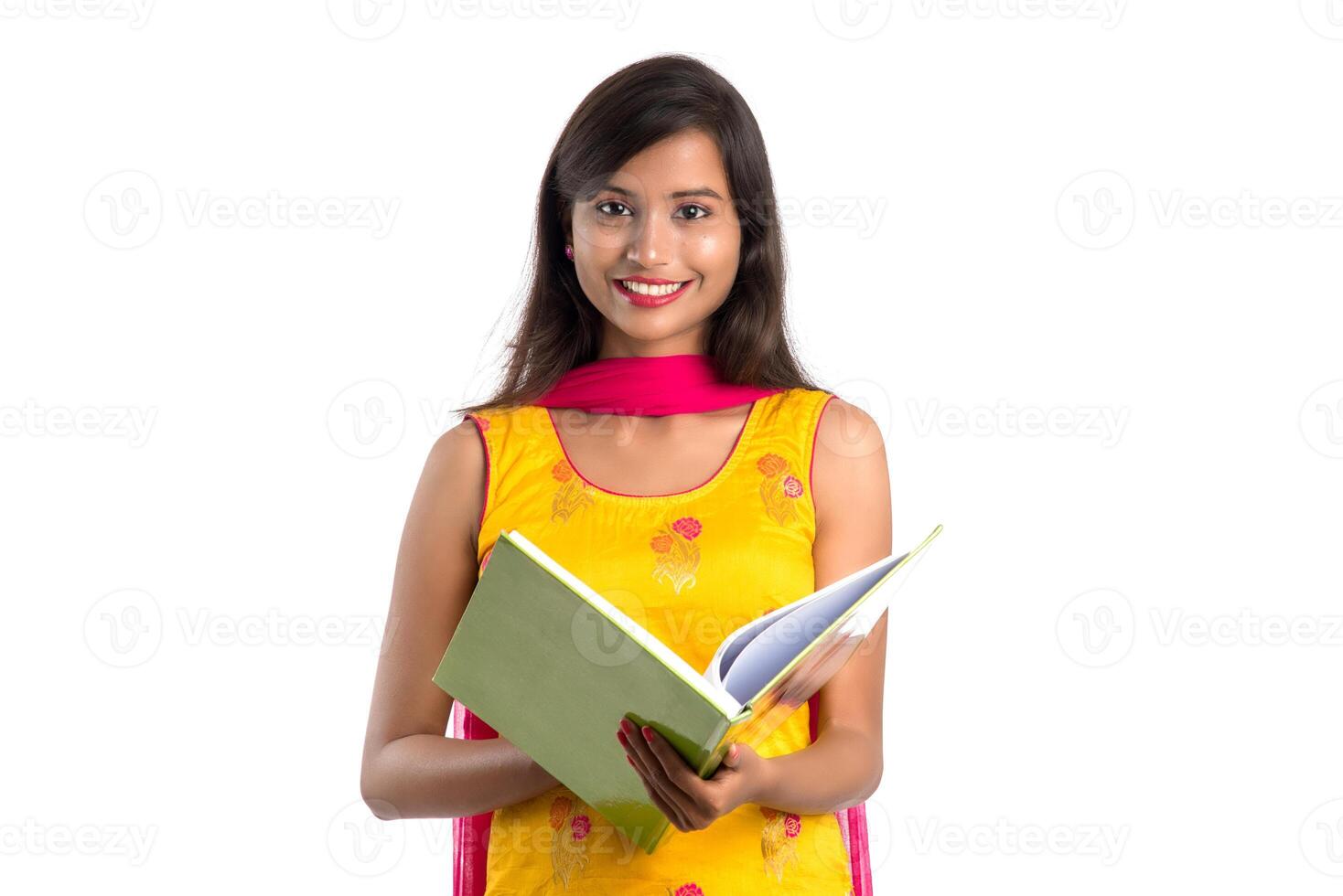 Pretty young girl holding book and posing on white background photo