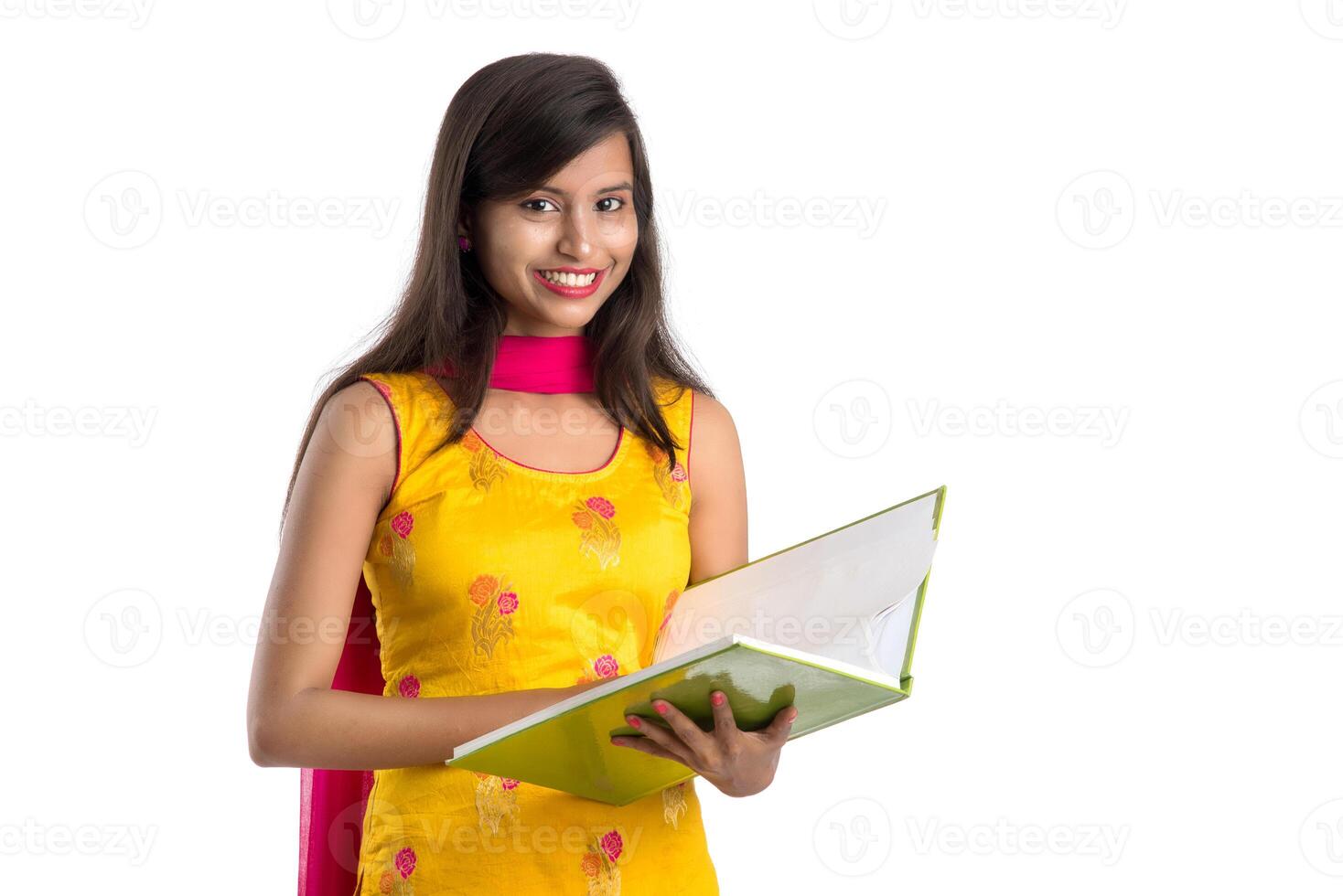 Pretty young girl holding book and posing on white background photo