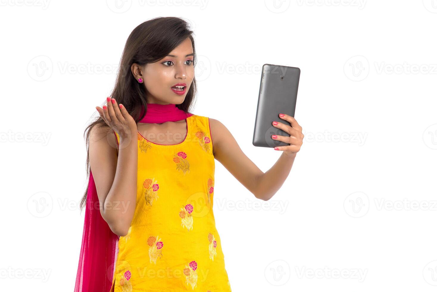 Young Indian girl using a Tablet, mobile phone or smartphone isolated on a white background photo