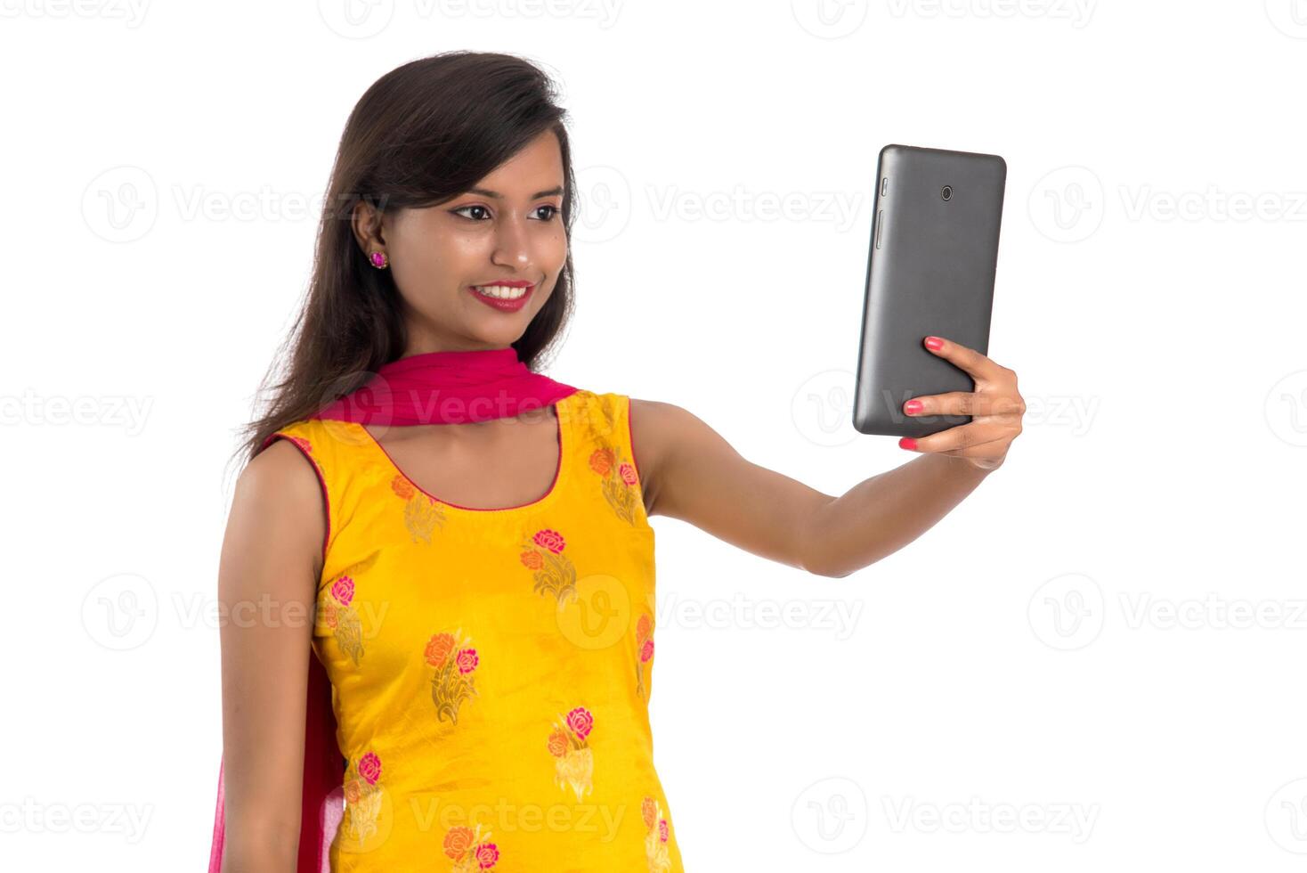 Young Indian girl using a Tablet, mobile phone or smartphone isolated on a white background photo