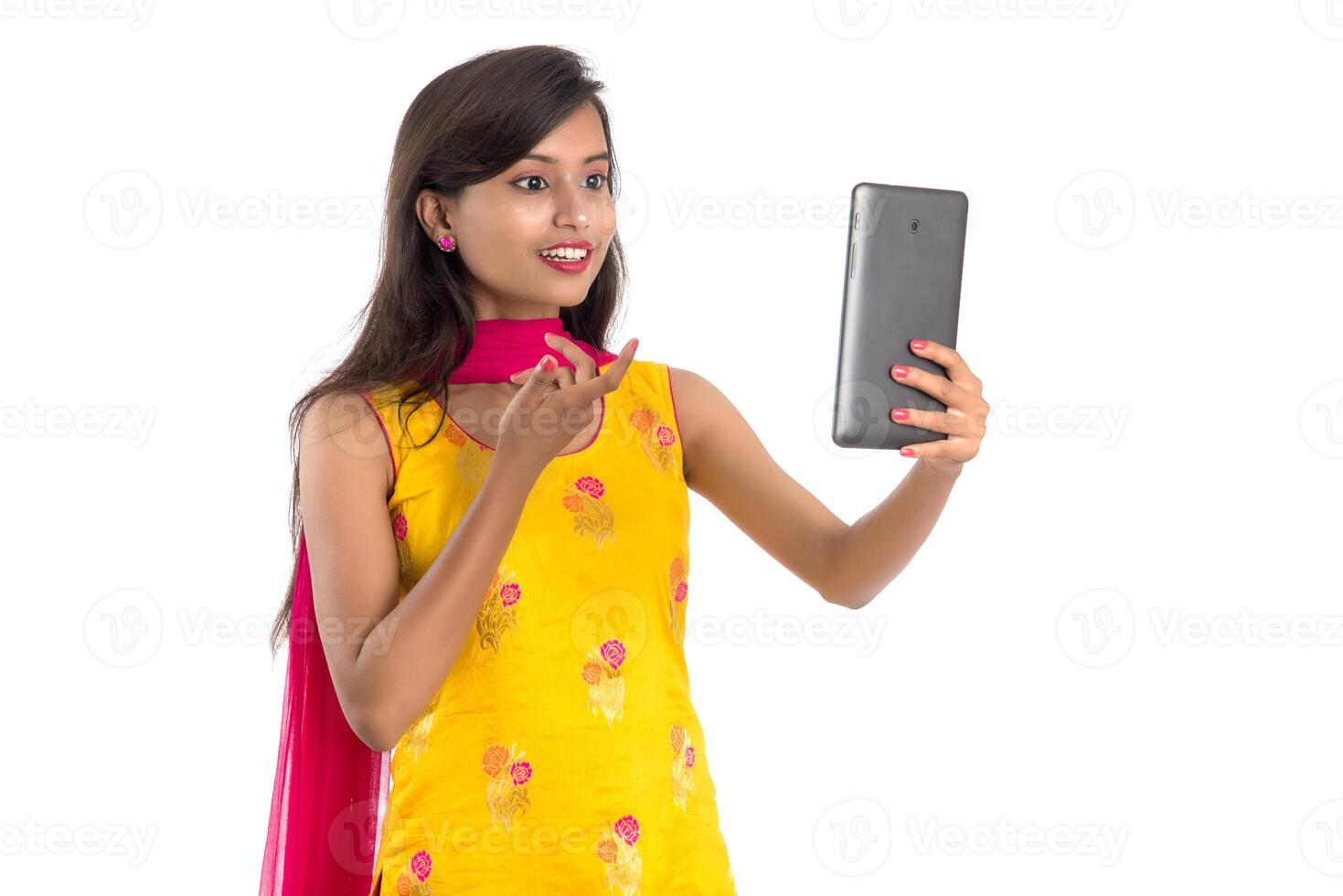 Young Indian girl using a Tablet, mobile phone or smartphone isolated on a white background photo