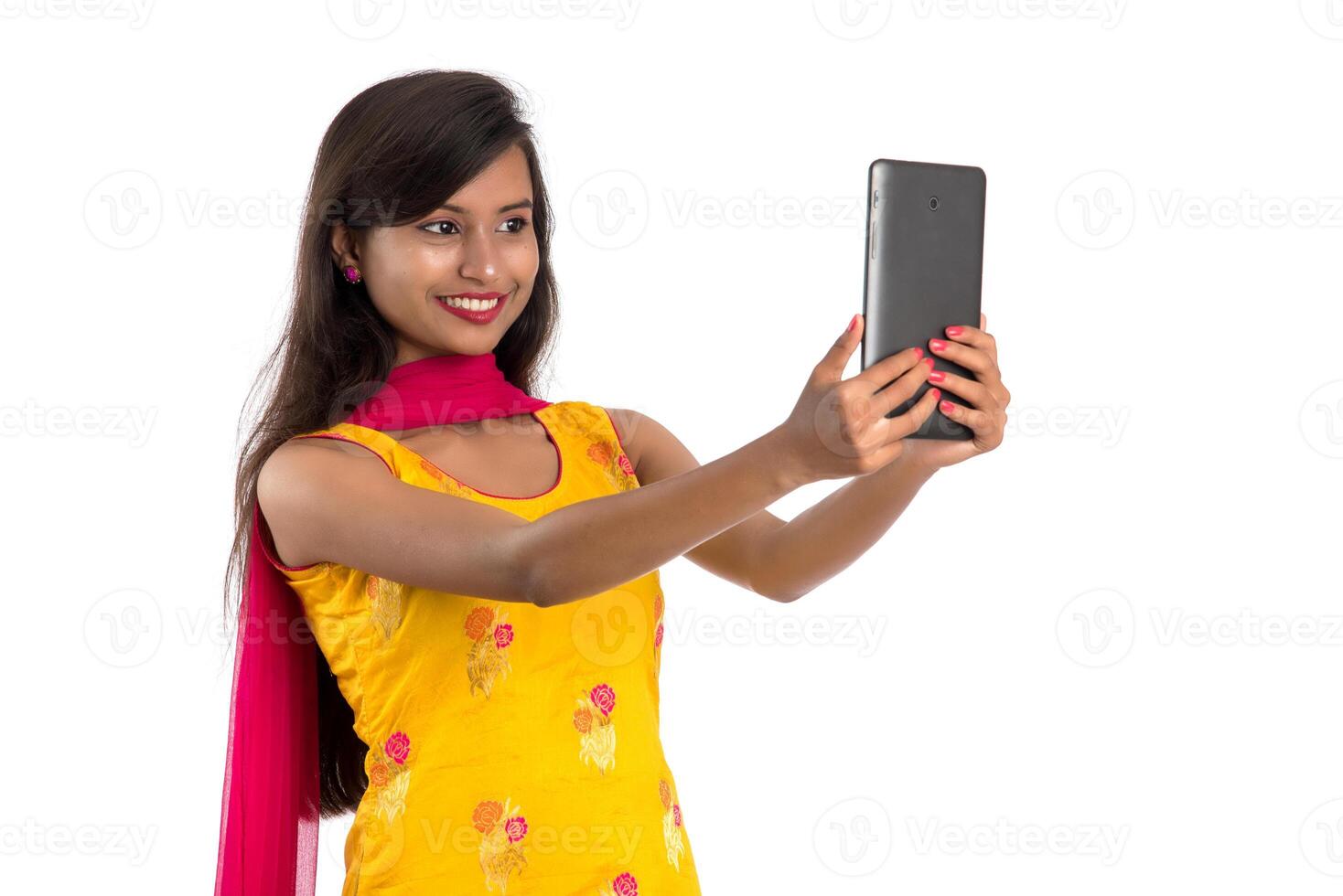 Young Indian girl using a mobile phone or smartphone isolated on a white background photo