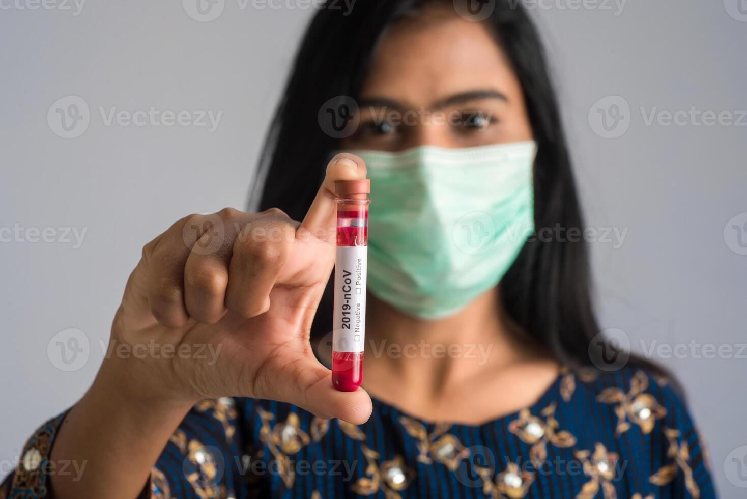Young girl holding a test tube with blood sample for coronavirus or 2019-nCoV analyzing. photo