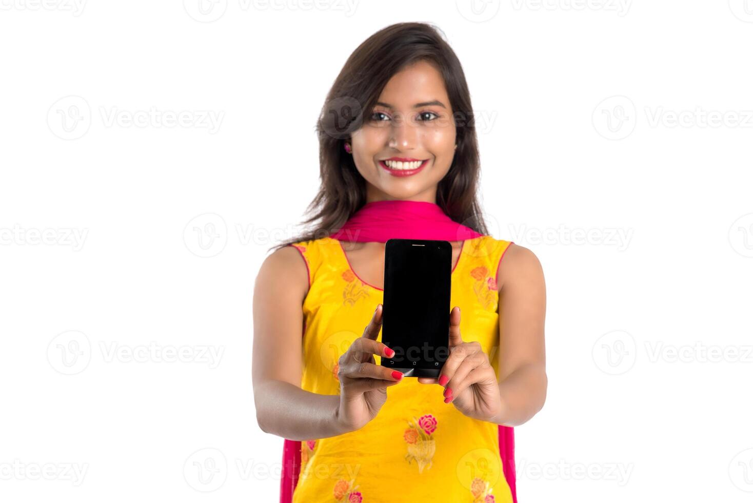 Young beautiful woman holding and showing blank screen smartphone or mobile or tablet phone on a white background. photo