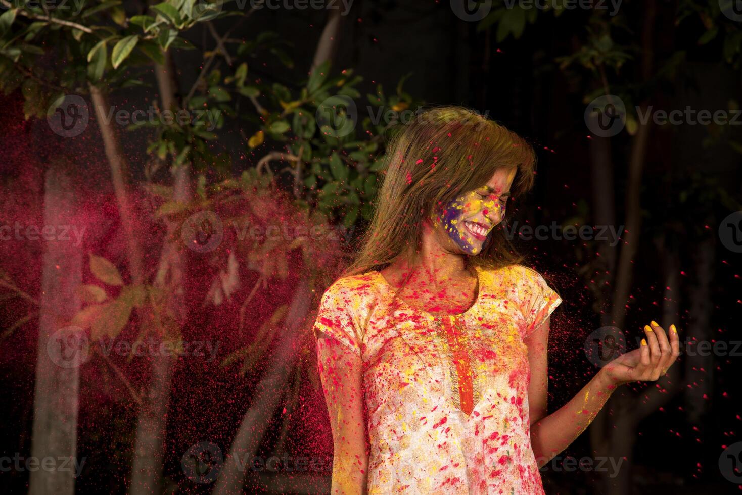 Young girl plays with colors on the occasion of Holi. Concept for Indian festival Holi. color splash. photo