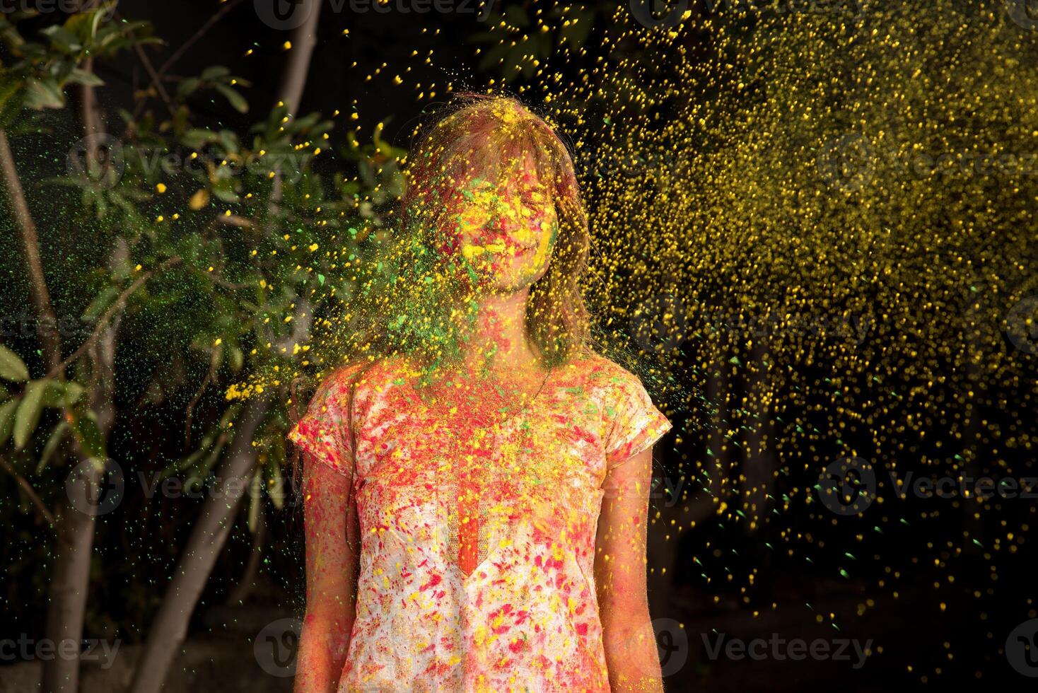Young girl plays with colors on the occasion of Holi. Concept for Indian festival Holi. color splash. photo