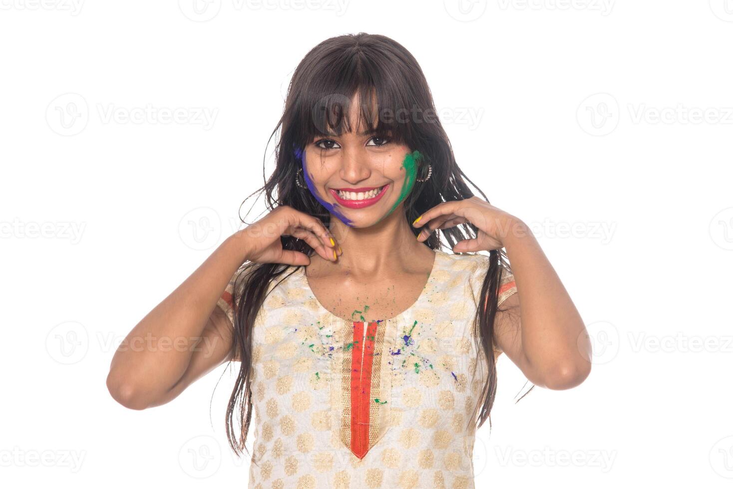 Beautiful young girl posing with colorful face in the occasion of Holi festival on white background. photo