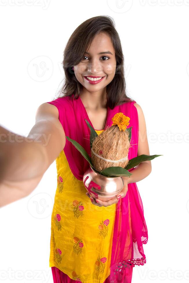 Beautiful young happy girl taking selfie with Kalash using a camera or smartphone on a white background photo