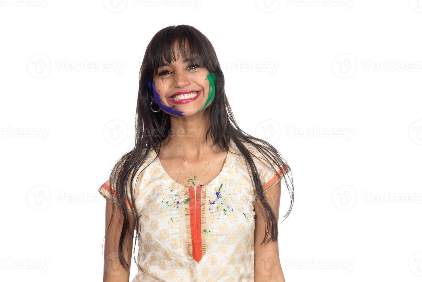Beautiful young girl posing with colorful face in the occasion of Holi festival on white background. photo