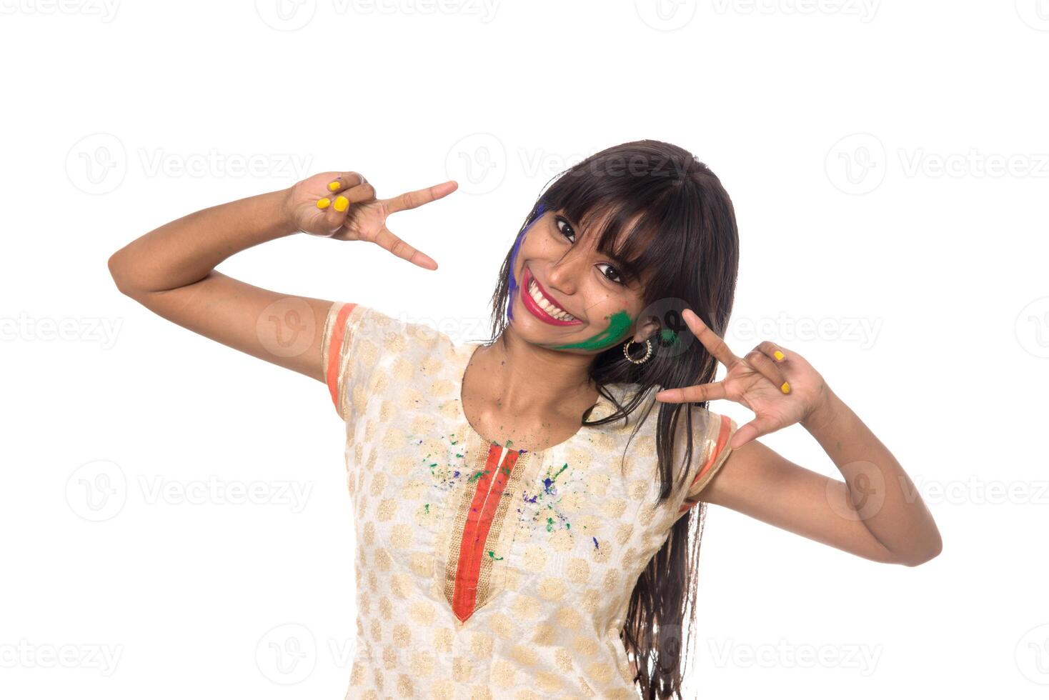 Beautiful young girl posing with colorful face in the occasion of Holi festival on white background. photo