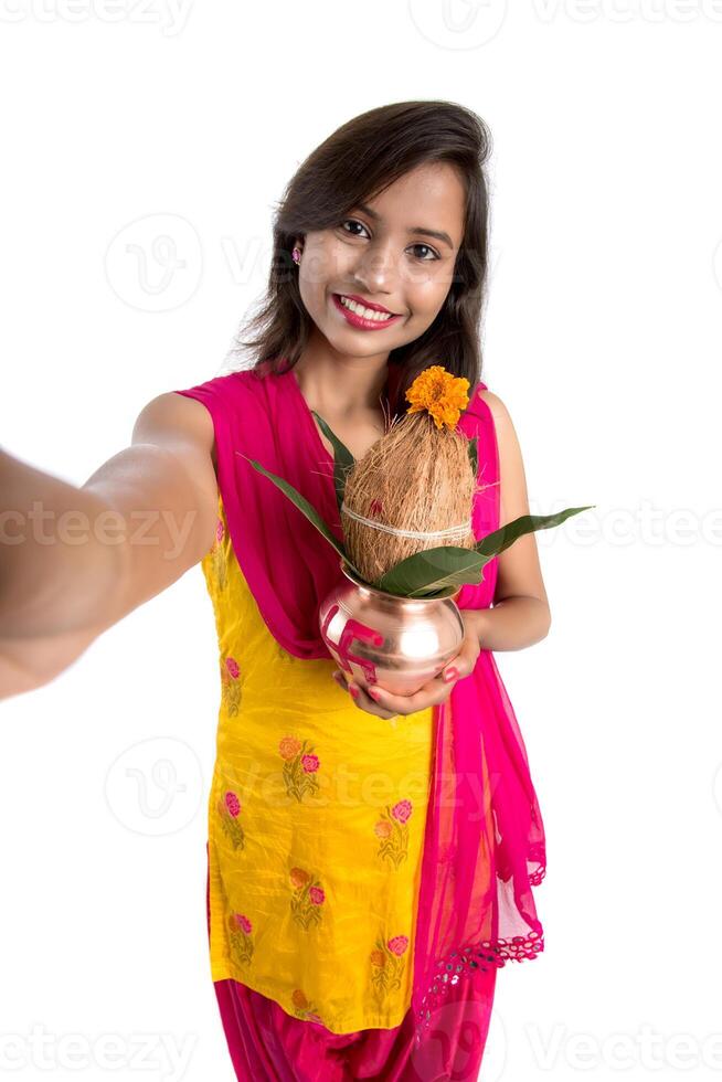 Beautiful young happy girl taking selfie with Kalash using a camera or smartphone on a white background photo