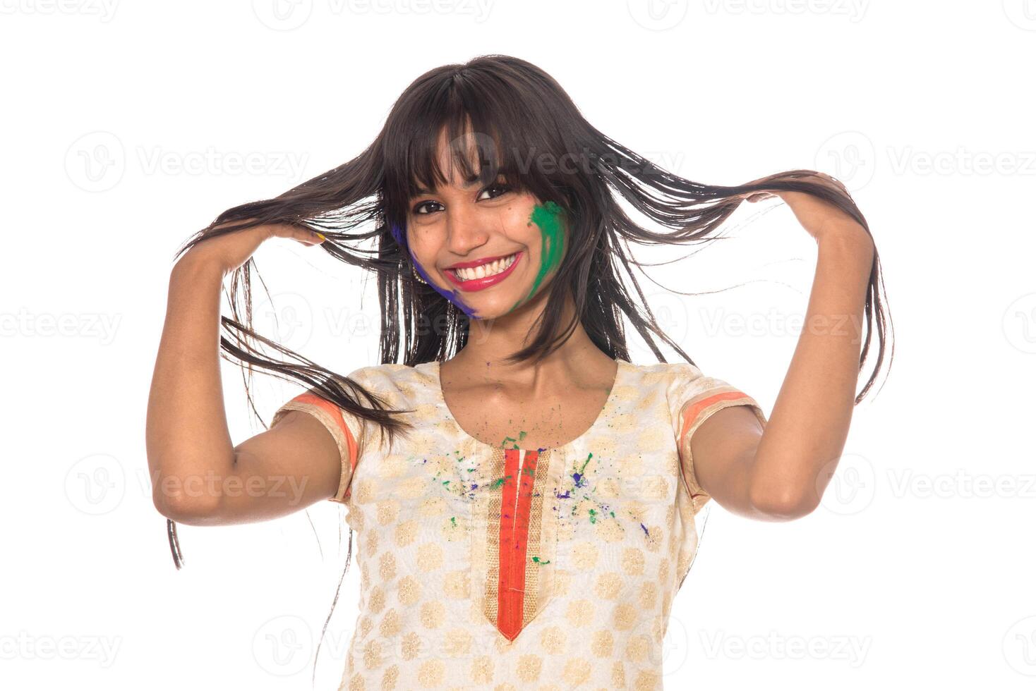 Beautiful young girl posing with colorful face in the occasion of Holi festival on white background. photo