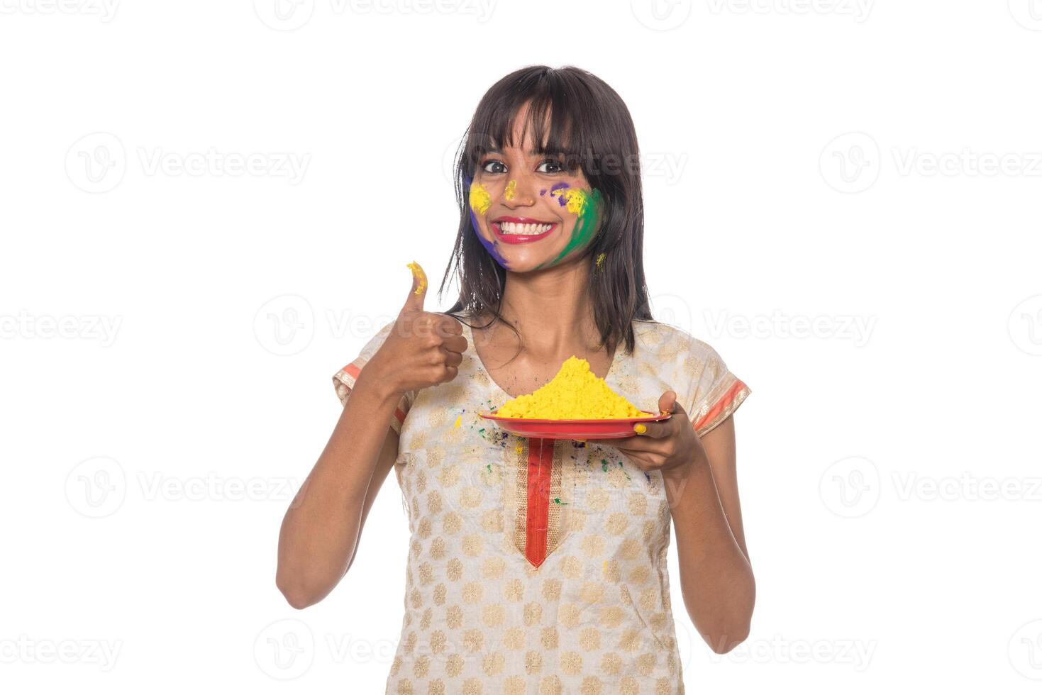 Beautiful young girl holding powdered color in plate on the occasion of Holi festival. photo