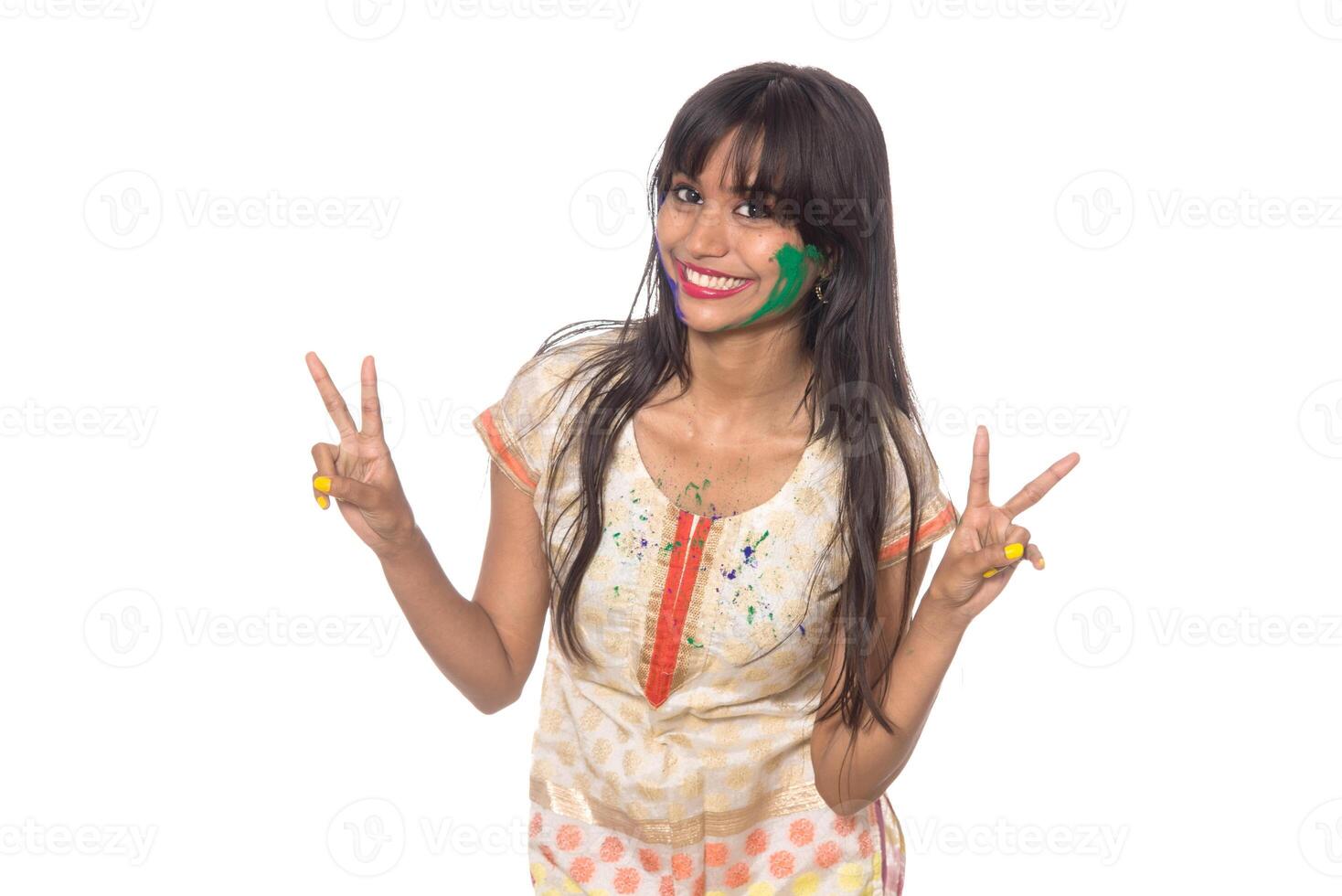 Beautiful young girl posing with colorful face in the occasion of Holi festival on white background. photo
