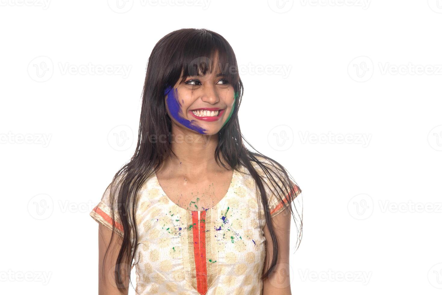 Beautiful young girl posing with colorful face in the occasion of Holi festival on white background. photo