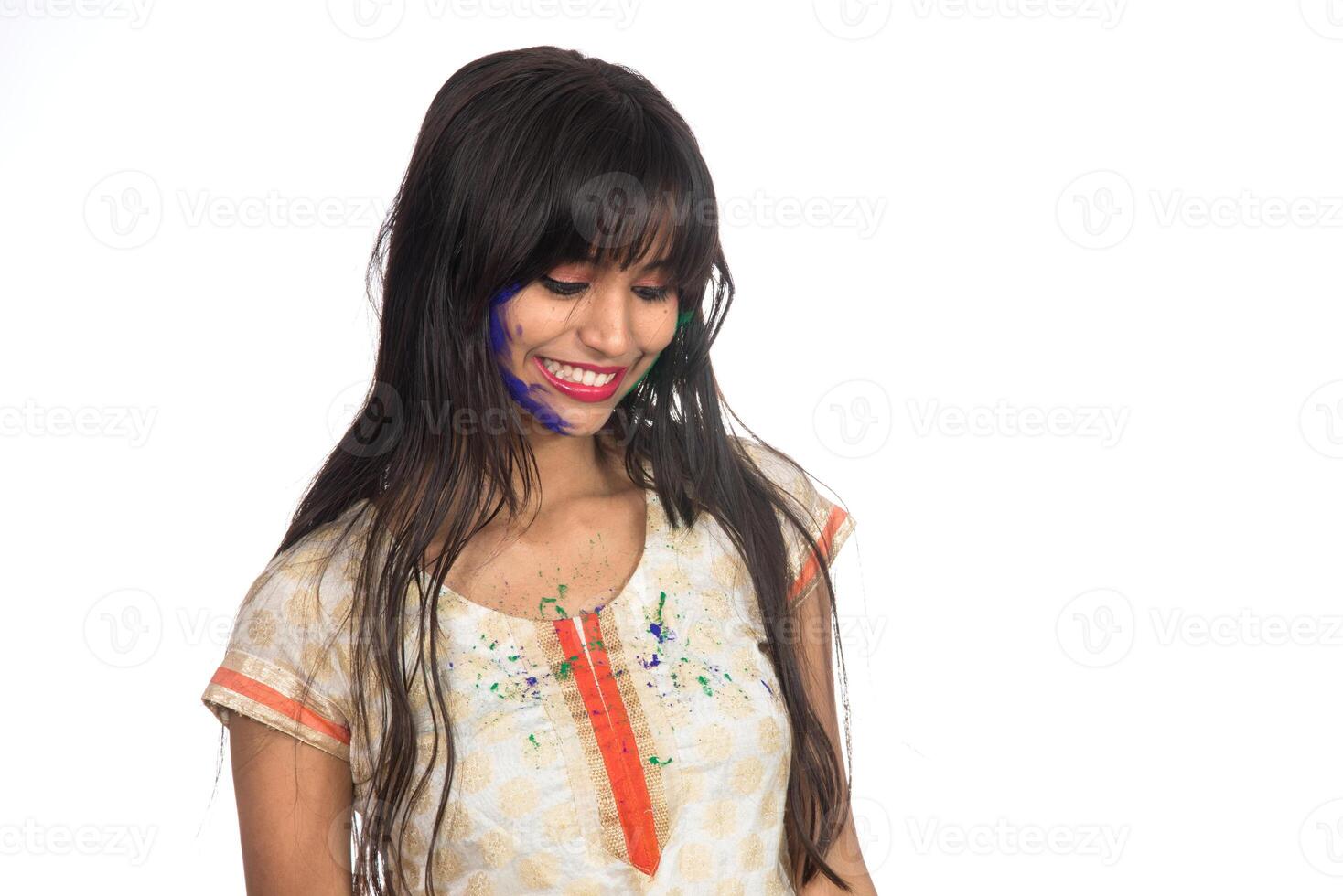 Beautiful young girl posing with colorful face in the occasion of Holi festival on white background. photo