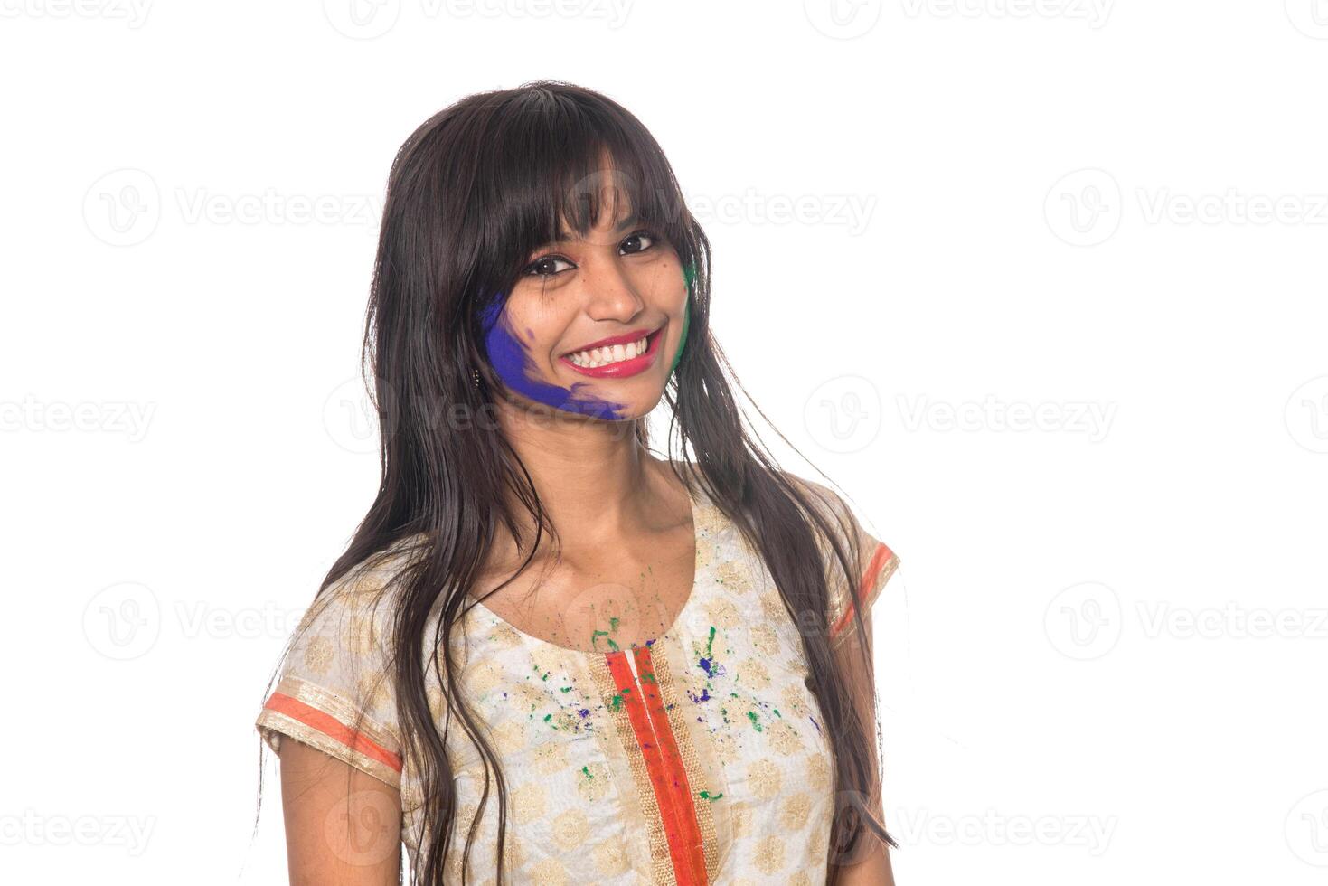 Beautiful young girl posing with colorful face in the occasion of Holi festival on white background. photo