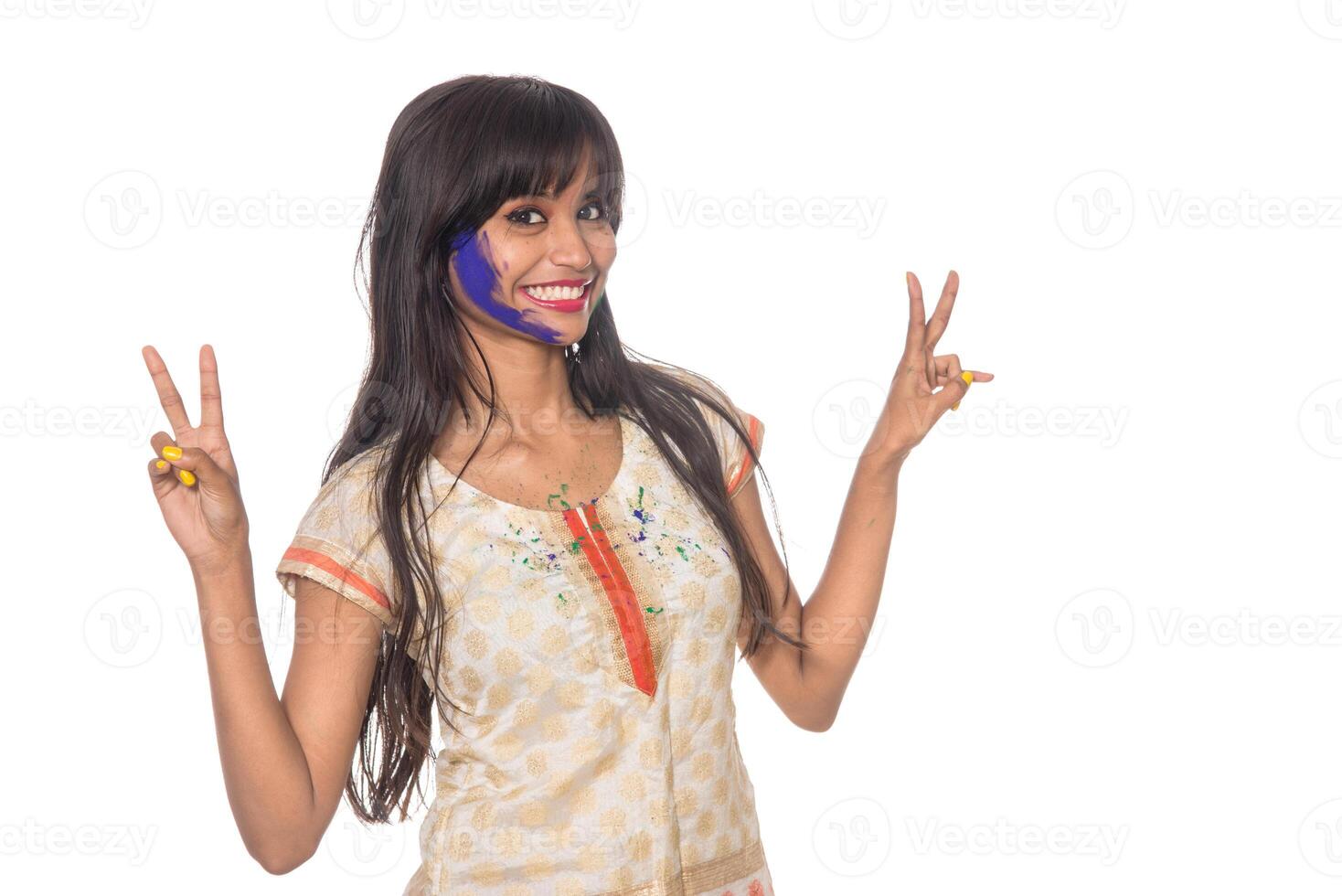 Beautiful young girl posing with colorful face in the occasion of Holi festival on white background. photo