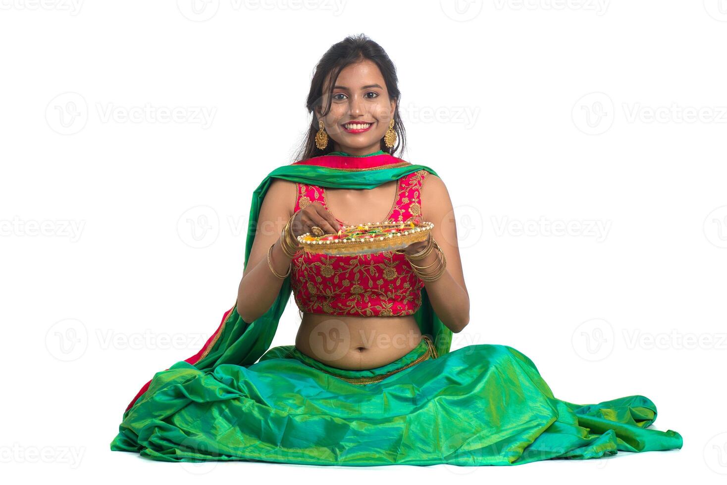 Portrait of a Indian Traditional Girl holding Diya, Girl Celebrating Diwali or Deepavali with holding oil lamp during festival of light on white background photo