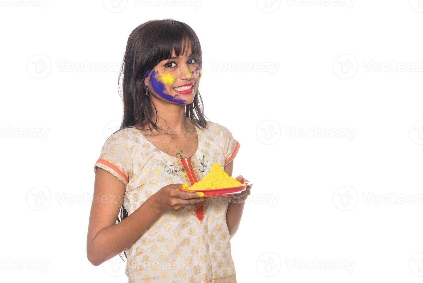 Beautiful young girl holding powdered color in plate on the occasion of Holi festival. photo