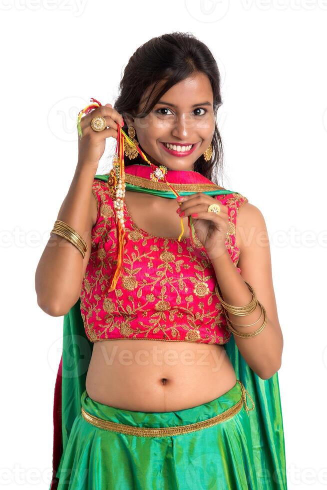 Beautiful girl showing Rakhi on occasion of Raksha bandhan on a white background. Sister tie Rakhi as symbol of intense love for her brother. photo