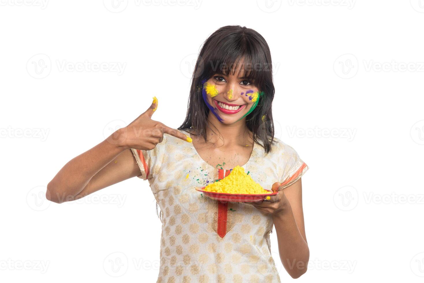 Beautiful young girl holding powdered color in plate on the occasion of Holi festival. photo