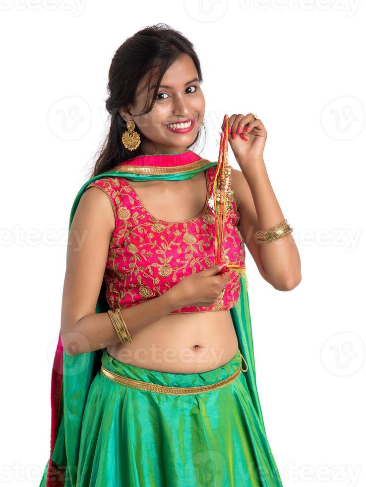 Beautiful girl showing Rakhi on occasion of Raksha bandhan on a white background. Sister tie Rakhi as symbol of intense love for her brother. photo