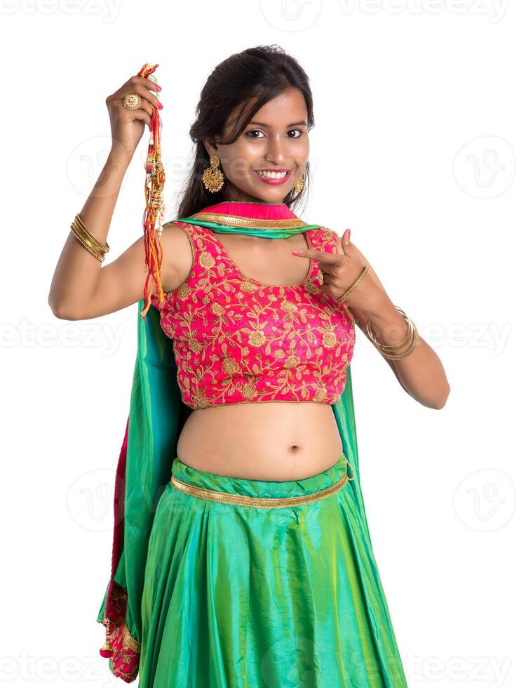 Beautiful girl showing Rakhi on occasion of Raksha bandhan on a white background. Sister tie Rakhi as symbol of intense love for her brother. photo