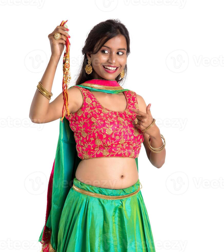 Beautiful girl showing Rakhi on occasion of Raksha bandhan on a white background. Sister tie Rakhi as symbol of intense love for her brother. photo