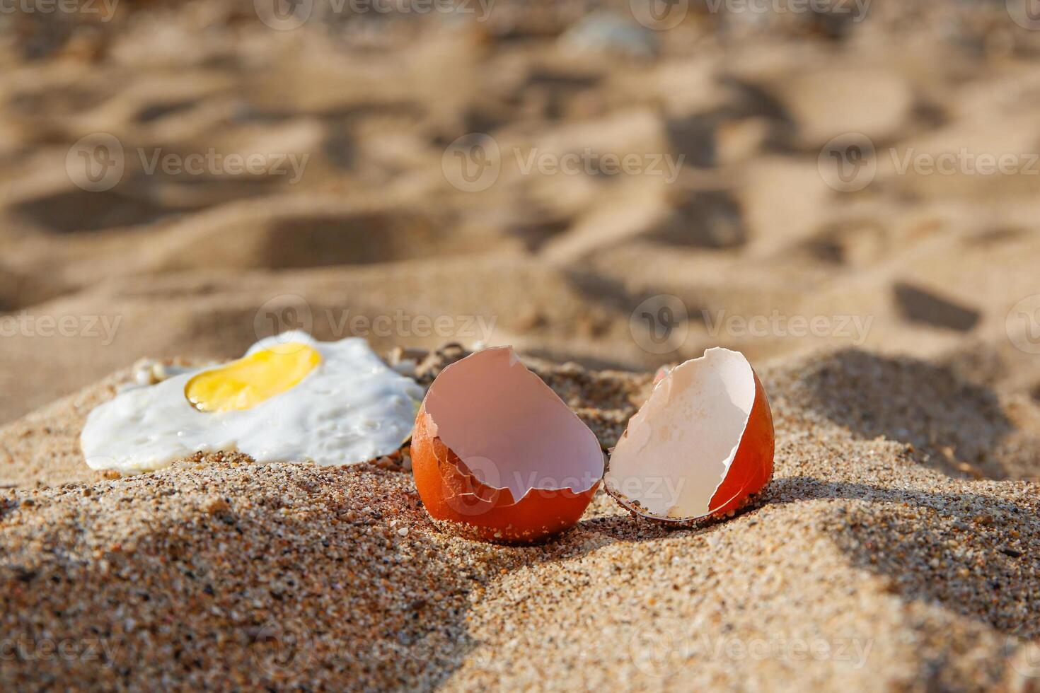 A chicken egg was fried in the sand. Hot weather on the beach. photo