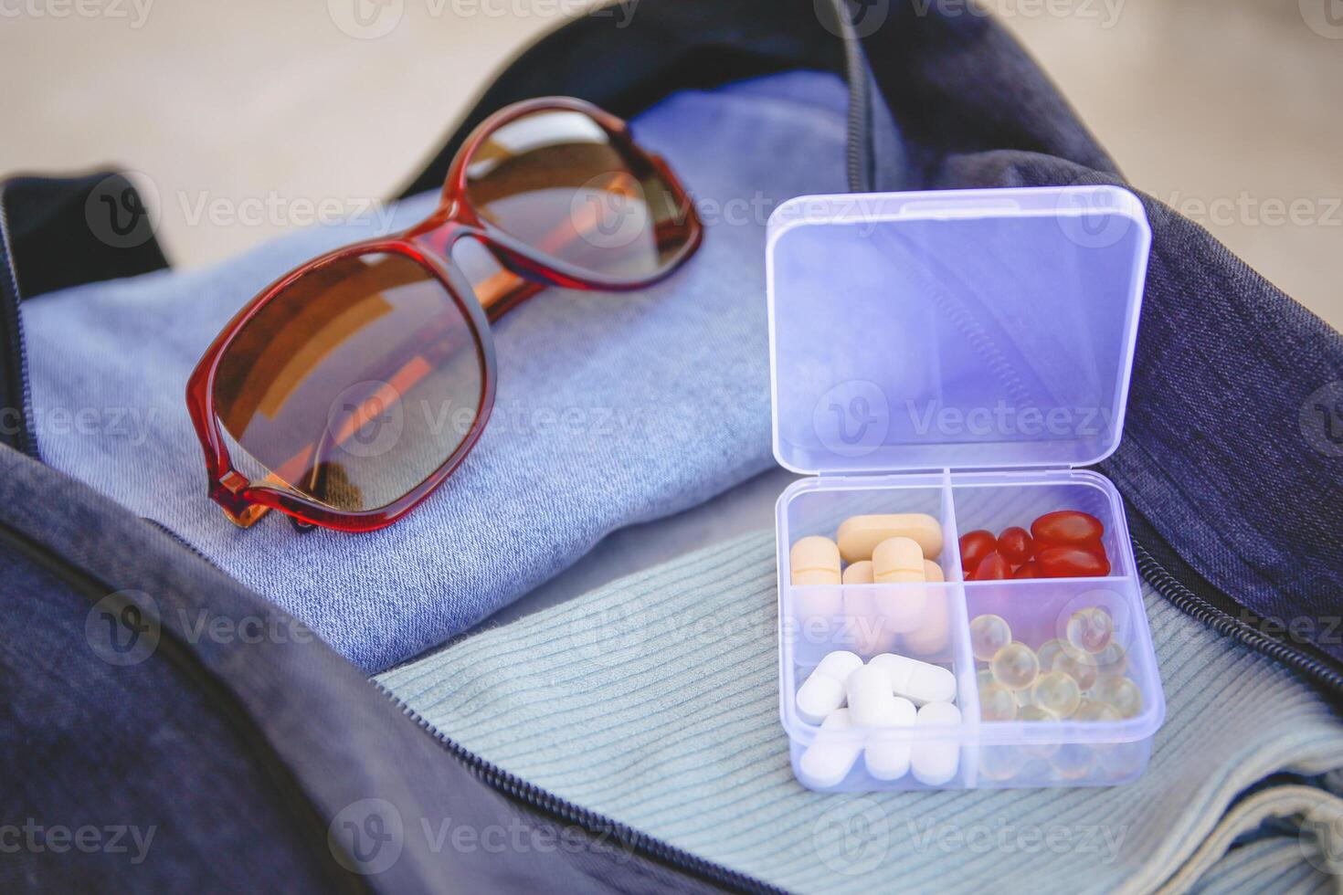 Clothes and pills in a travel bag. Concept of medication required in journey photo