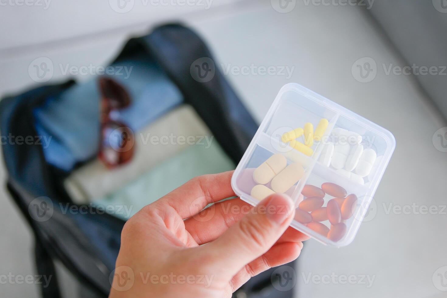 Clothes and pills in a travel bag. Concept of medication required in journey photo
