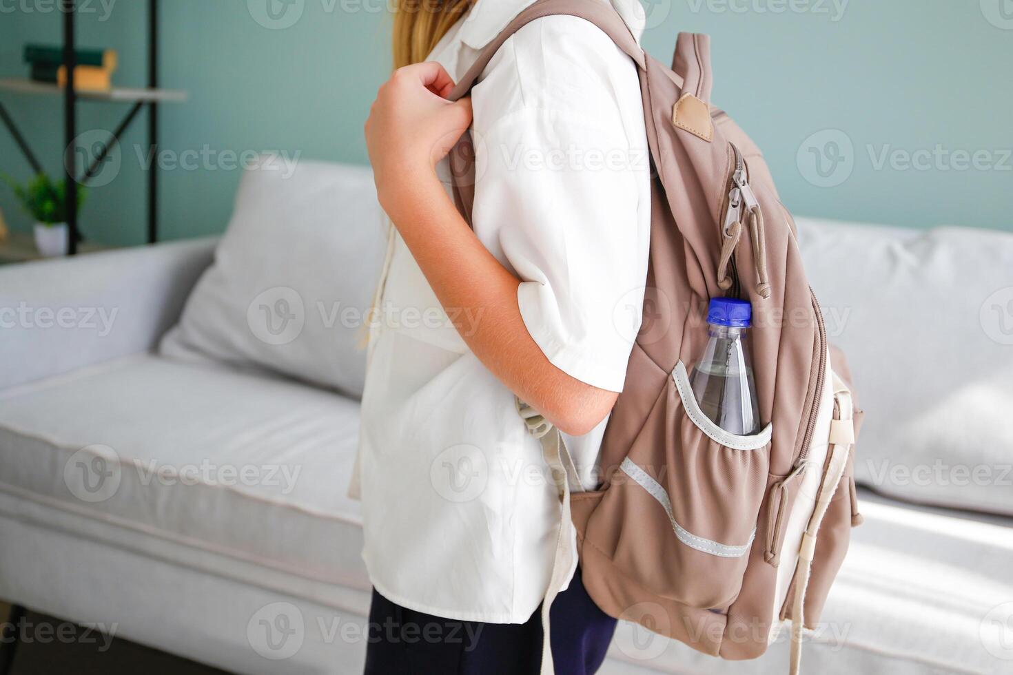 There is a bottle of water in the school backpack. photo